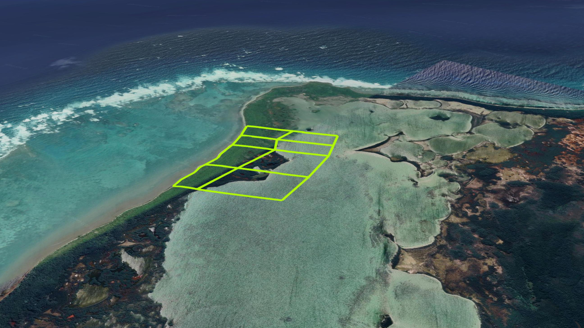 Wider aerial view of the Bacalar Beach holding showing the Caribbean horizon, barrier reef and contiguous parcel layout along Ambergris Caye.